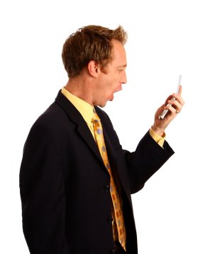 A young businessman in a suit screaming at a cell phone. By: Benjamin Miller. License FSP Standard FreeStockPhotos.biz   